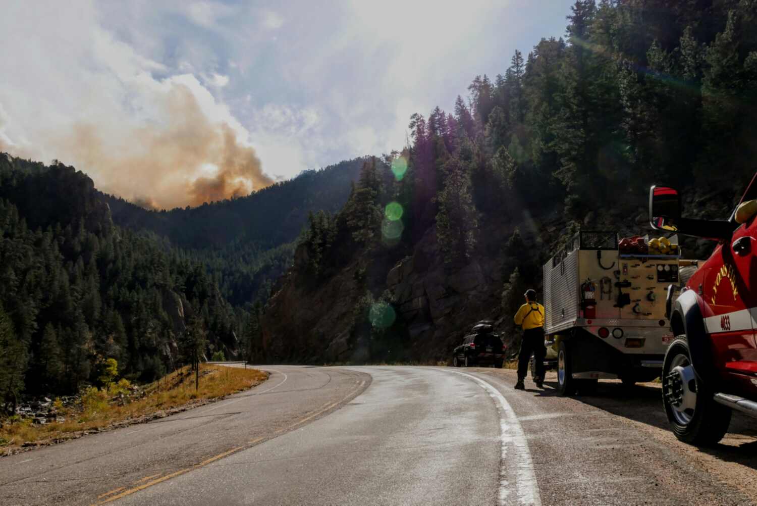 fire truck on roadside with wildfire smoke in distance